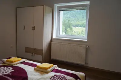 a bedroom with a bed with two yellow towels on it at Apartma Mlinca 1 in Mojstrana