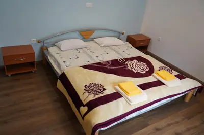 a bed in a room with two nightstands and a bed with a blanket at Apartma Mlinca 1 in Mojstrana