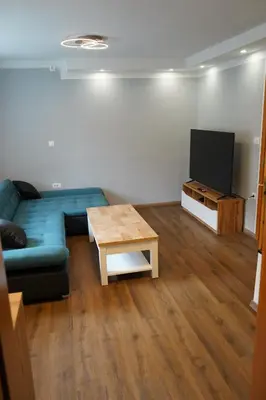 a living room with a blue couch and a tv at Apartma Mlinca 1 in Mojstrana