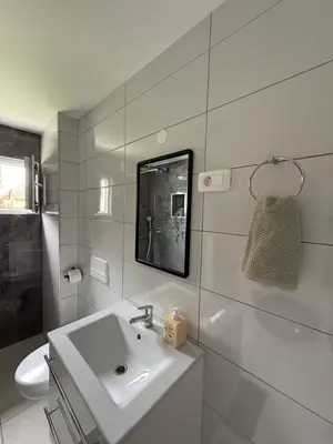 a white bathroom with a sink and a toilet at Natura Apartments in Kranj