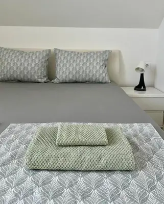a bed with two pillows on it in a bedroom at Natura Apartments in Kranj