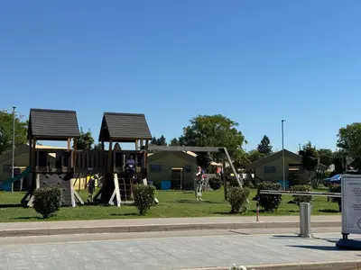 a playground in a park with houses in the background at Holzhaus in der Therme Čatež - familienfreundlich, Nähe WinterSommerRiviera in Brežice
