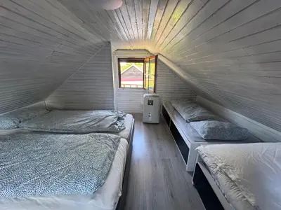 two beds in a small room with a window at Holzhaus in der Therme Čatež - familienfreundlich, Nähe WinterSommerRiviera in Brežice
