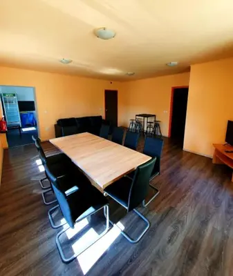 a conference room with a wooden table and chairs at Bled Hostel II in Bled