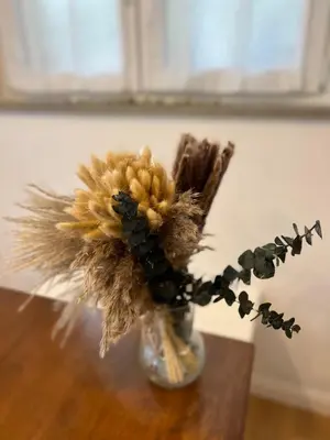 a vase filled with dried flowers on a table at Lazy Goose Charming Apartments Bovec in Bovec