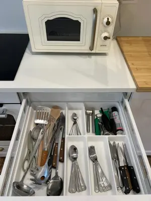 a kitchen drawer filled with utensils and a microwave at Lazy Goose Charming Apartments Bovec in Bovec