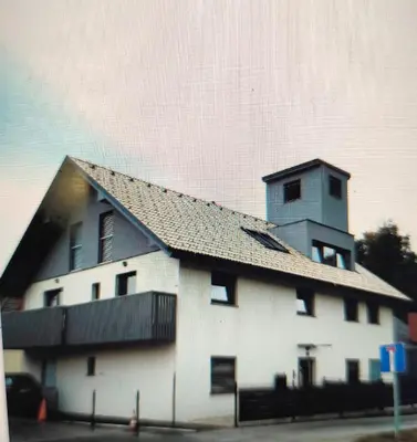 a white building with a tower on top of it at Slovenian Green Apartment in Radovljica