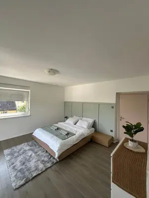 a bedroom with a large bed and a potted plant at Toni's house in Bled