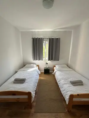 two twin beds in a room with a window at Toni's house in Bled
