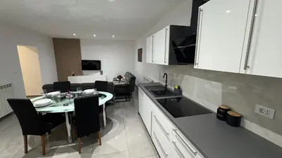 a kitchen with a table and chairs in a room at Pri Drevoredu in Prvačina