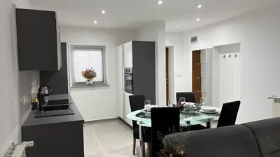 a kitchen and dining room with a table and a couch at Pri Drevoredu in Prvačina