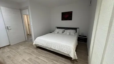 a white bedroom with a bed with white sheets and pillows at Pri Drevoredu in Prvačina