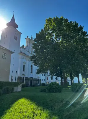 a large white building with a tree in front of it at Gostilna Menina in Gornji Grad