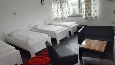 a room with white beds and a chair and a window at Gril Ranca pod Pohorjem in Maribor