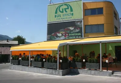 a group of people sitting at a restaurant in front of a building at Gril Ranca pod Pohorjem in Maribor