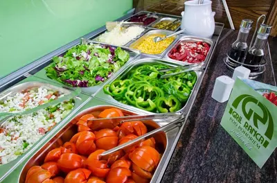 a buffet of food with tomatoes and vegetables in trays at Gril Ranca pod Pohorjem in Maribor