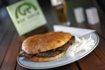 a meat sandwich on a plate on a table at Gril Ranca pod Pohorjem in Maribor