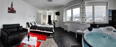 a bathroom with a tub and a couch and a sink at Gril Ranca pod Pohorjem in Maribor