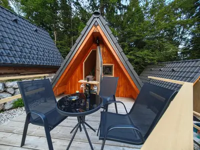 a patio with a table and chairs in front of a cabin at AirWood Glamping in Križe