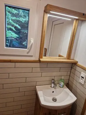 a bathroom with a sink and a mirror and a window at AirWood Glamping in Križe