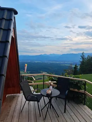 a patio with two chairs and a table on a deck at AirWood Glamping in Križe