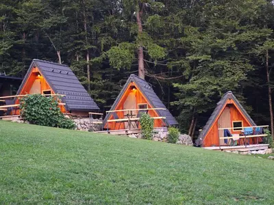 a group of three huts on a hill at AirWood Glamping in Križe