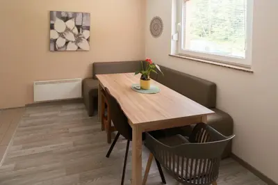 a dining room table with a vase of flowers on it at Hiša pod Veliko planino in Stahovica