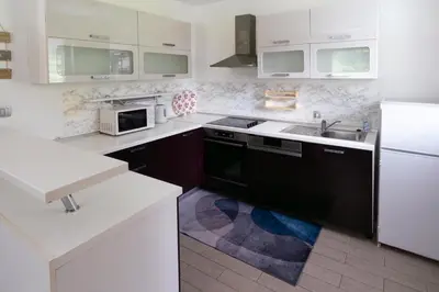 a white kitchen with a sink and a stove at Hiša pod Veliko planino in Stahovica