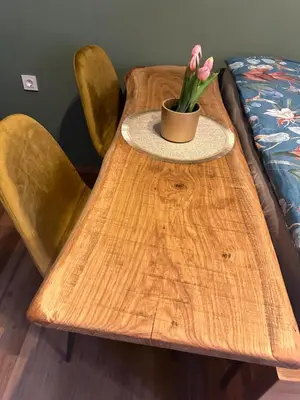 a wooden table with a pot of flowers on it at My Star Apartment in Maribor