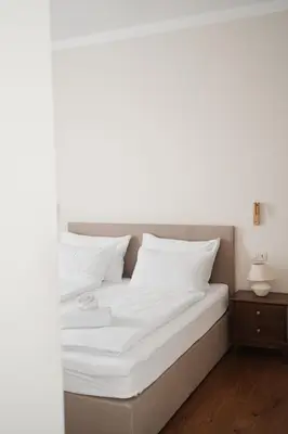 a bed with white sheets and pillows on it at Stara šola Kaval in Novo Mesto