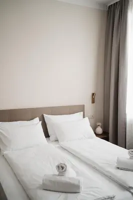 a large white bed with two towels on it at Stara šola Kaval in Novo Mesto