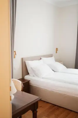 two large white beds in a room with a table at Stara šola Kaval in Novo Mesto