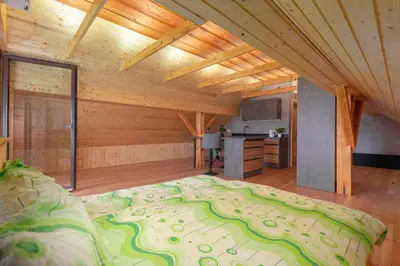 a large bed in a room with a kitchen at The Barn Košnik in Kranj