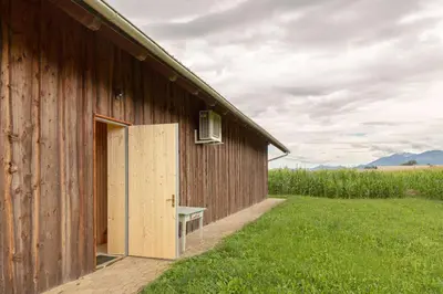 an open door to a barn with a bench outside at The Barn Košnik in Kranj