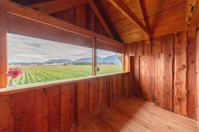 a room with a window with a view of a field at The Barn Košnik in Kranj