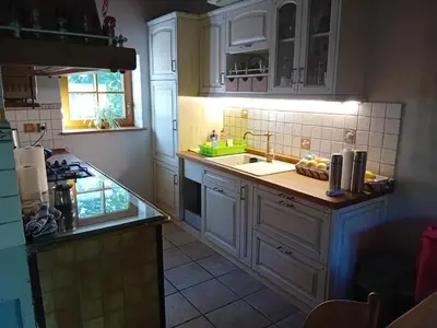 a kitchen with white cabinets and a sink at Hiša Šujica in Ljubljana