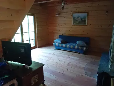 a living room with a blue couch in a log cabin at Hiša Šujica in Ljubljana