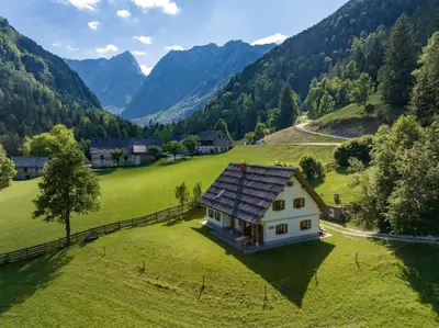 a house with a solar roof on a green field at Mala hiša in Solčava