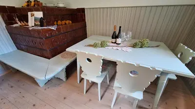 a white table and chairs with wine bottles and glasses at Forest House Henriette in Ig