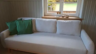 a white couch with two green pillows on it at Forest House Henriette in Ig