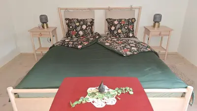 a bedroom with a large bed with a green comforter at Forest House Henriette in Ig