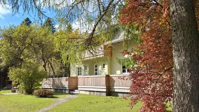 a white house with a fence and trees at Forest House Henriette in Ig