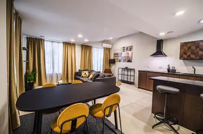a kitchen and a living room with a table and chairs at Cankar's Private Place The Luxe in Ljubljana