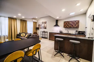 a kitchen and living room with a table and chairs at Cankar's Private Place The Luxe in Ljubljana