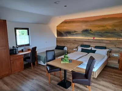 a bedroom with a bed and a table with chairs at Romantisches Kellerstöckl - Jeruzalem in Ivanjkovci