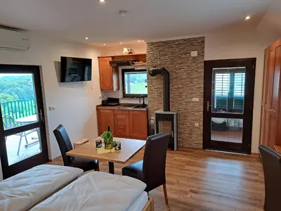 a living room with a dining room table and a tv at Romantisches Kellerstöckl - Jeruzalem in Ivanjkovci