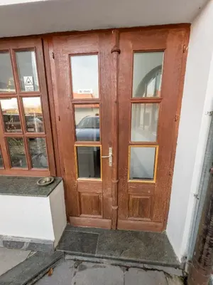 a wooden door with windows on a building at By the river Ljubljana apartment in Rove