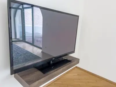 a flat screen tv on a wall with a window at By the river Ljubljana apartment in Rove