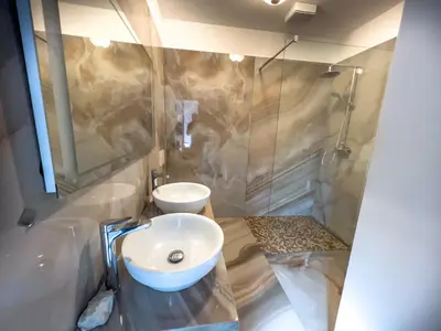 a bathroom with a sink and a shower at By the river Ljubljana apartment in Rove