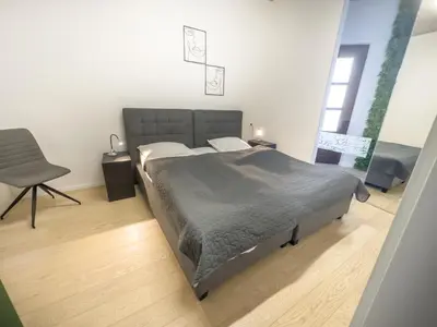 a bedroom with a bed and a chair in it at Eiprova by the river in Ljubljana